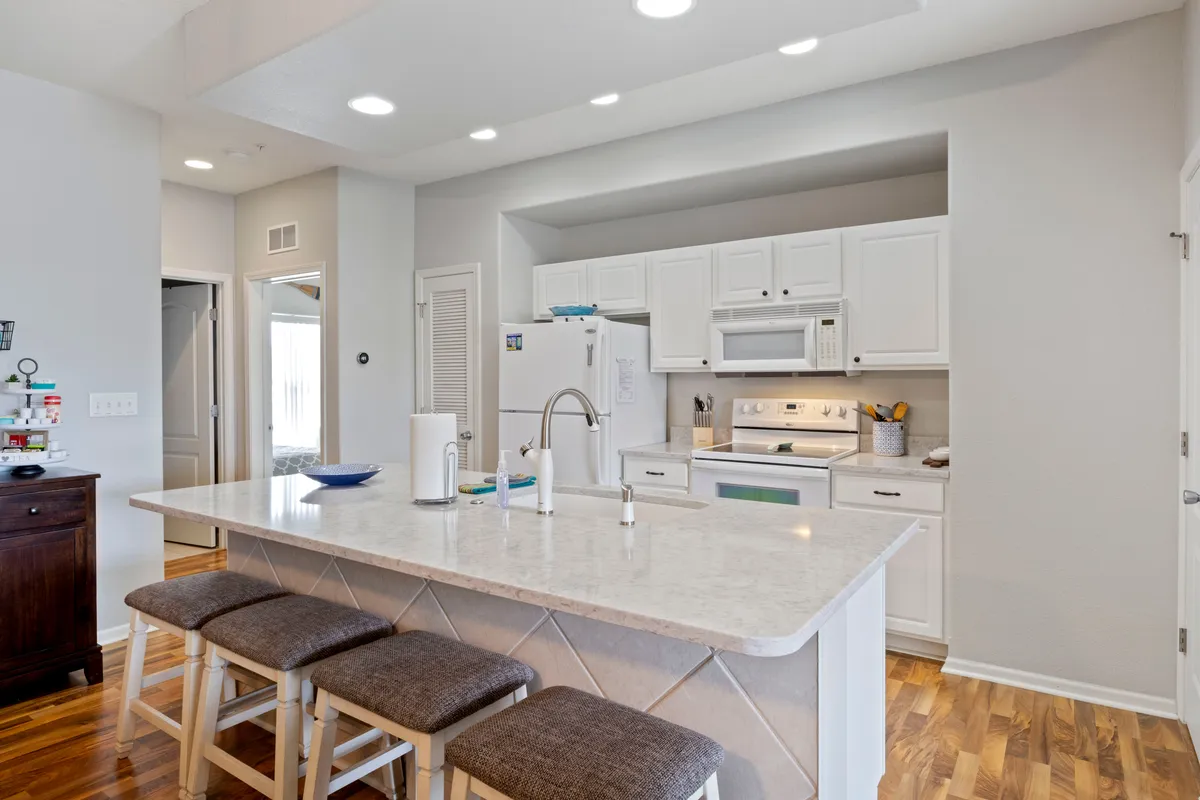 This photo spotlights a kitchen island with white cabinetry and stainless steel appliances, representing the heart of the home where daily routines are both convenient and comfortable. The modern finishes hint at upgraded, smart features central to enhanced comfort.